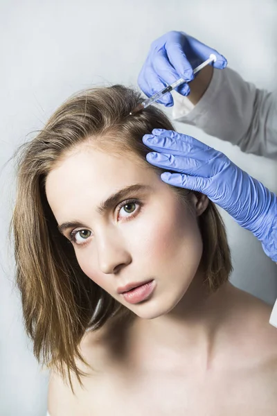 Doctor aesthetician makes head beauty injections to beautiful female patient — Stock Photo, Image
