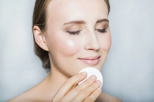 Genç sarışın güzel kız ile makyaj ve pamuk yastık yüzü