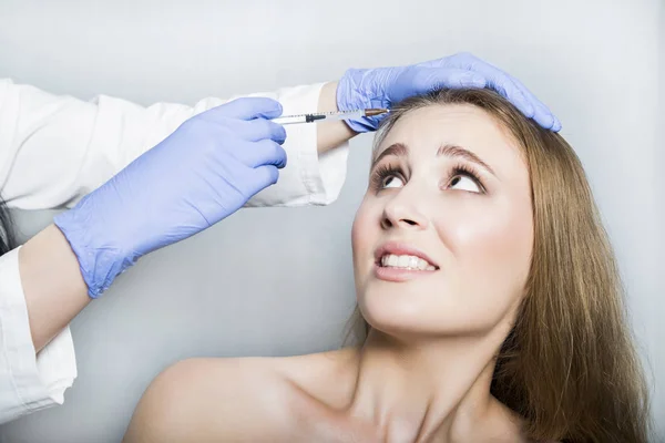 Kadın hastaya baş güzellik iğne yapmaya çalışan doktor ö