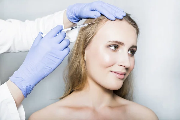 Doctor aesthetician makes head beauty injections to female patient on white background — Stock Photo, Image