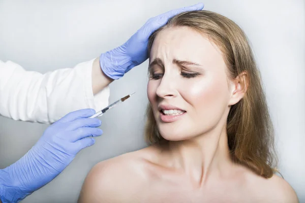 Doctor aesthetician trying to make head beauty injections to female patient — Stock Photo, Image