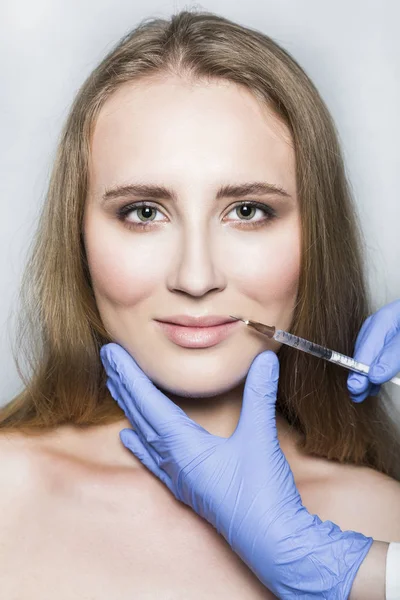 Doctor aesthetician makes lips correction and augmentation to female patient — Stock Photo, Image