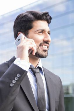 Gülümseyen iş adamı veya elbise ile telefonu ofis binası yakınındaki işçi
