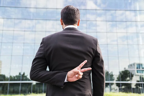 Uomo d'affari o lavoratore in giacca e cravatta mostra segno di pace vicino edificio per uffici — Foto Stock