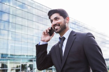 Gülümseyen iş adamı veya elbise ile telefonu ofis binası yakınındaki işçi