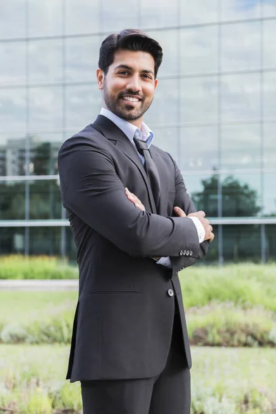 Glimlachend zakenman of werknemer permanent in pak in de buurt van kantoorgebouw — Stockfoto