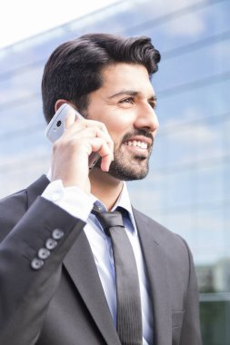 Gülümseyen iş adamı veya elbise ile telefonu ofis binası yakınındaki işçi