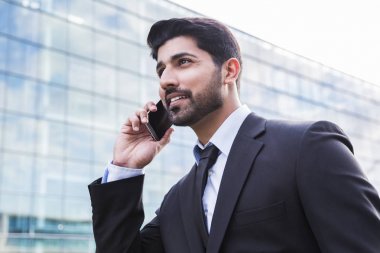 Gülümseyen iş adamı veya elbise ile telefonu ofis binası yakınındaki işçi