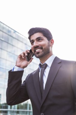 Gülümseyen iş adamı veya elbise ile telefonu ofis binası yakınındaki işçi
