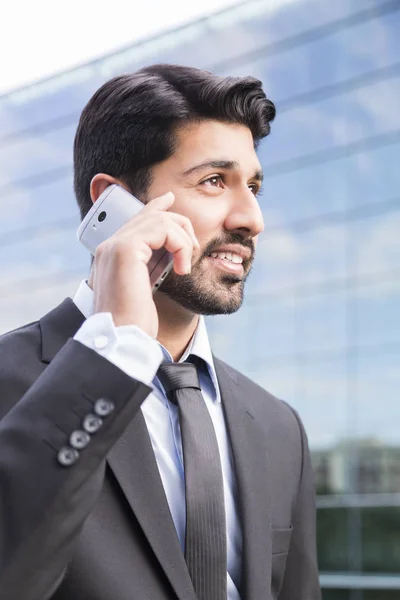 Gülümseyen iş adamı veya elbise ile telefonu ofis binası yakınındaki işçi