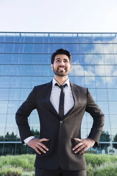 Empresário sorridente ou trabalhador em pé de terno perto de prédio de escritórios — Fotografia de Stock
