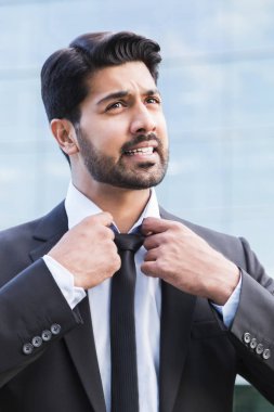 Kızgın işadamı veya işçi ayakta takım elbise ve kravat düzleştirme