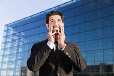 Kızgın işadamı veya işçi ayakta elle yüzündeki takım elbiseli