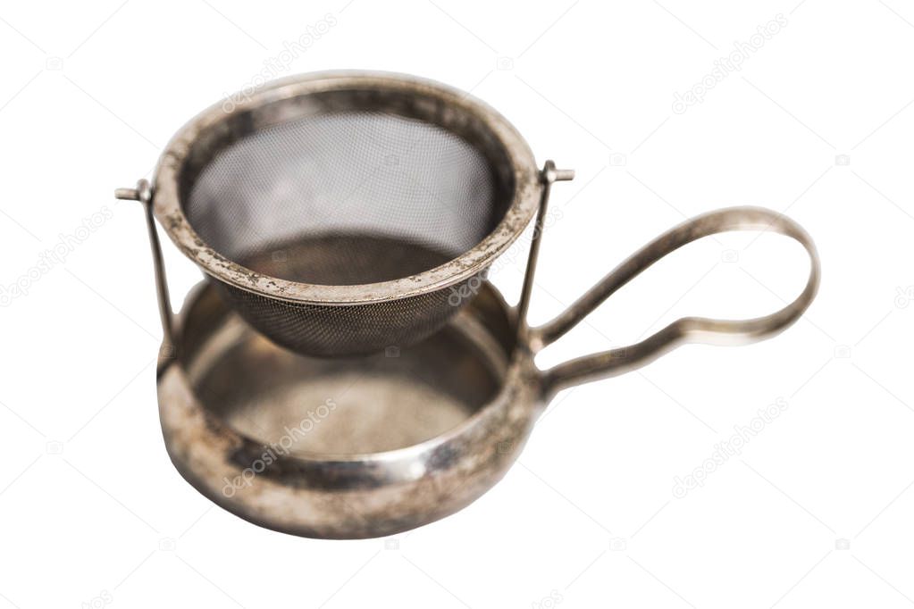 Steel old vintage tea strainer with metal saucer and handle on isolated background.