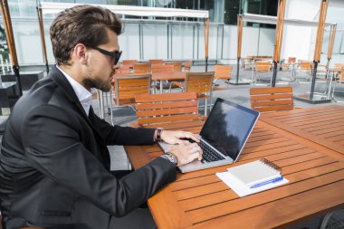 Erkek iş adamı veya alt masa ve bilgisayar üzerinde çalışan siyah elbiseli.