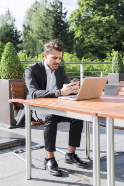 Erkek işadamı ya da alt tablo ve seyir telefon siyah elbiseli