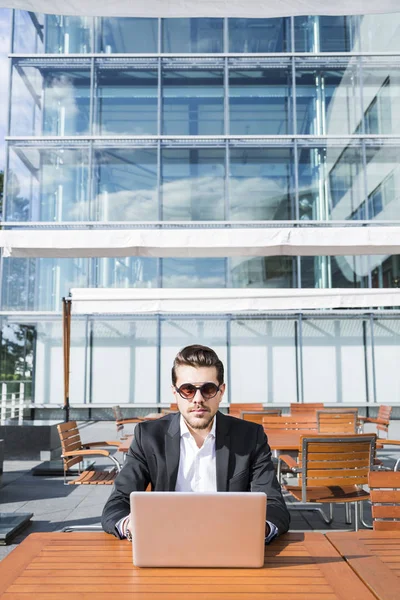 Uomo d'affari o lavoratore in giacca e cravatta nera a tavola e al computer . — Foto Stock