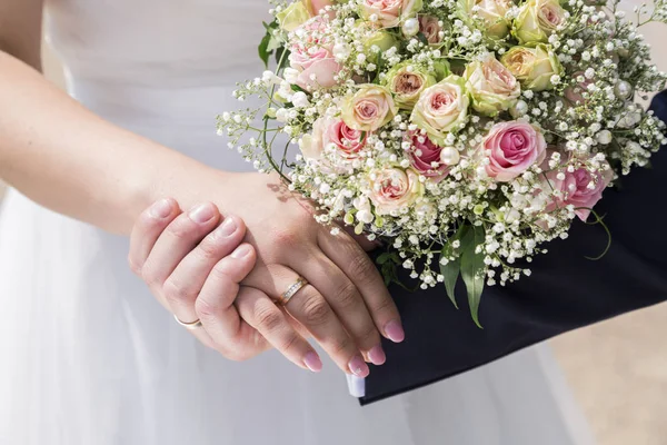 Pengantin pria dalam setelan jas dan pengantin wanita dalam gaun pengantin memegang tangan — Stok Foto