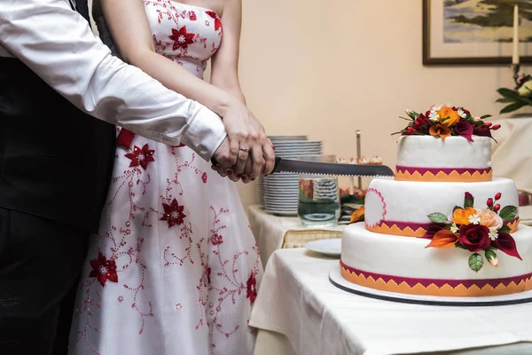 Novia y novio cortes con cuchillo blanco grande hermosa tarta de boda — Foto de Stock