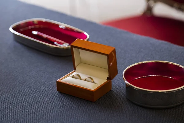 Два золотых блестящих обручальных кольца в деревянном гробу — стоковое фото