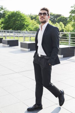 Erkek iş adamı veya siyah takım elbise işçi sokakta yürümek