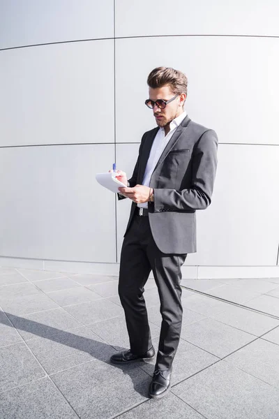 Uomo d'affari o lavoratore in abito nero scrivere in notebook . — Foto Stock