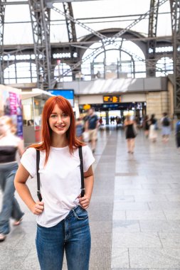 Genç tatlı kız tren istasyonunda tren bekliyor.