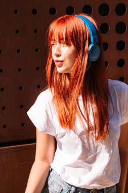 Genç bir kadın, güneşli bir sokakta dans ediyor.