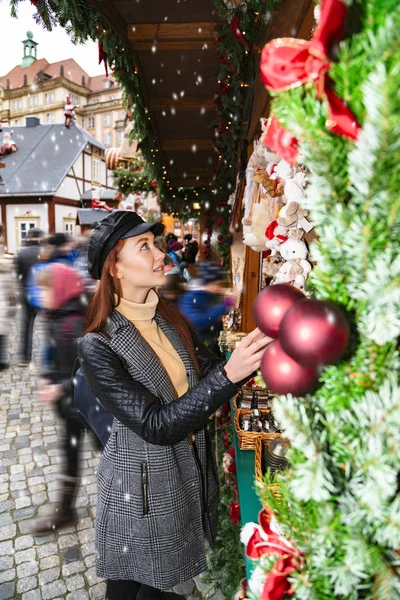Menina escolhe árvore de Natal na feira de rua — Fotografia de Stock