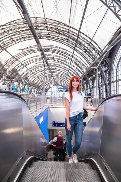 Menina tentando subir na escada rolante na estação de trem — Fotografia de Stock