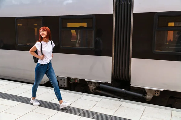 Jovem mulher andando plataforma ferroviária ao longo do trem — Fotografia de Stock