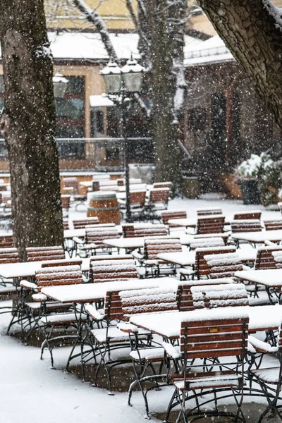 Outdoor cafe without visitors under falling snow — Stock Photo, Image