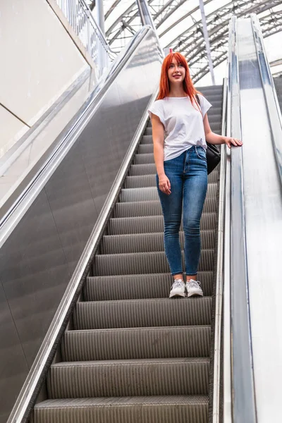 Menina vai para baixo em movimento escada segurando trilhos — Fotografia de Stock