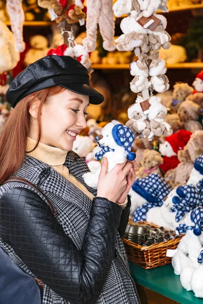 Menina fica perto de loja de brinquedos com urso macio nas mãos — Fotografia de Stock