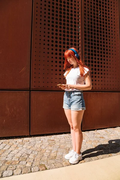 Фигура девушки в полный рост на улице с телефоном — стоковое фото