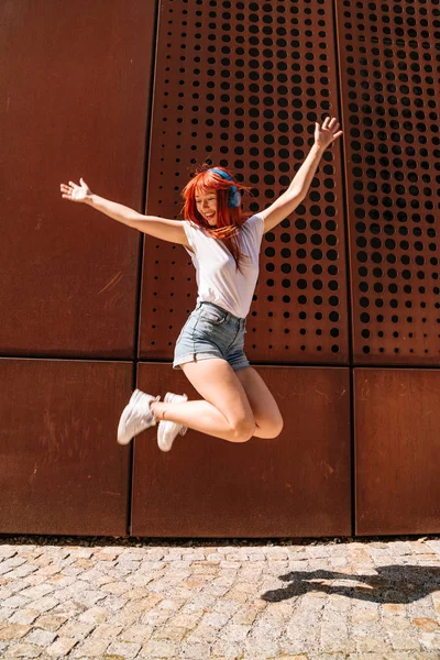 Молодая девушка танцует на улице и прыгает высоко — стоковое фото