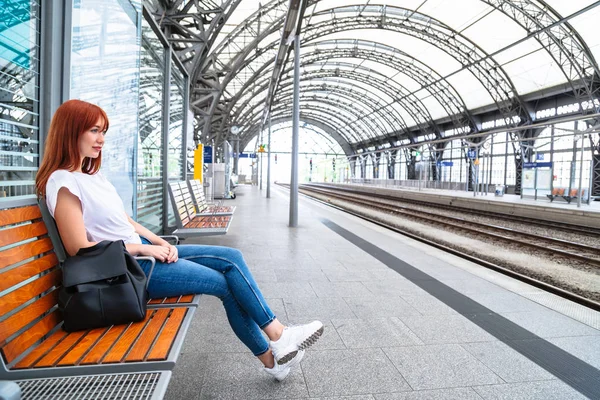Menina à espera de trem na estação sentado no banco — Fotografia de Stock