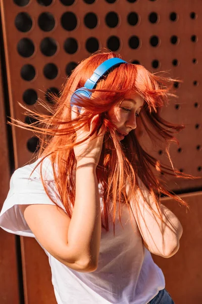 Девушка делает движения головы под музыку в наушниках — стоковое фото