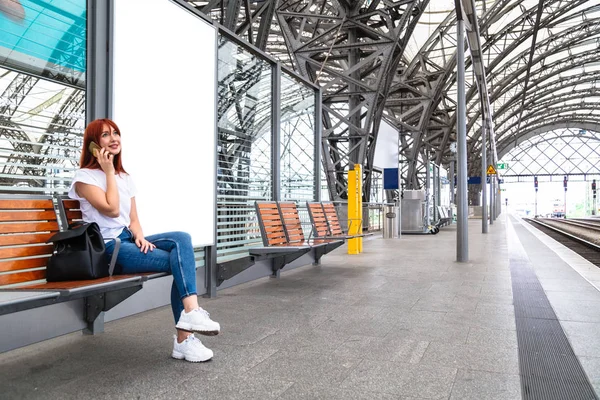 Viajante menina sentado no banco de madeira na estação — Fotografia de Stock