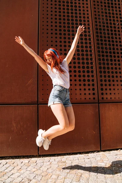 Молода дівчина танцює на вулиці і стрибає високо вгору — стокове фото