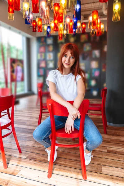 Retrato de menina sorridente sentada na cadeira no café — Fotografia de Stock