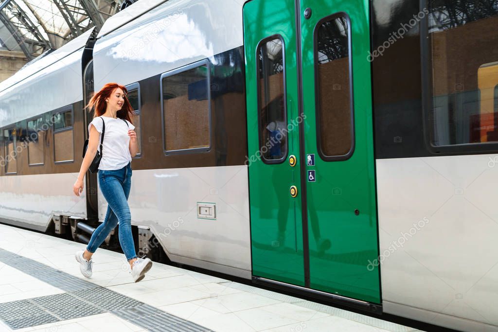 Woman at train station hurries to electric train
