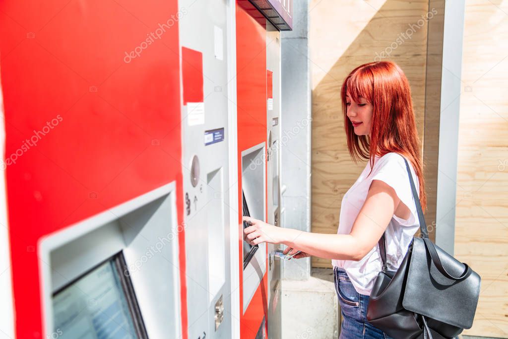 Woman touches screen of terminal to buy ticket