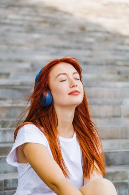 Portre kızı kulaklıkla müzik dinliyor.