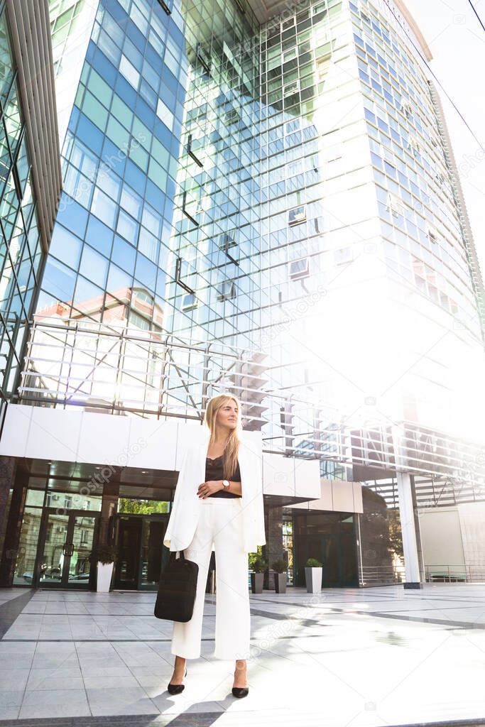 Young business woman in white suit outside