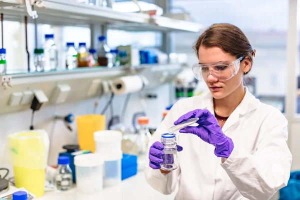 Menina em óculos de segurança preparar solução em laboratório — Fotografia de Stock