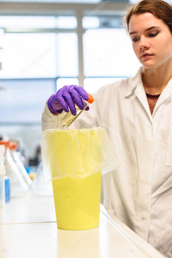 Researcher puts flask in container in laboratory