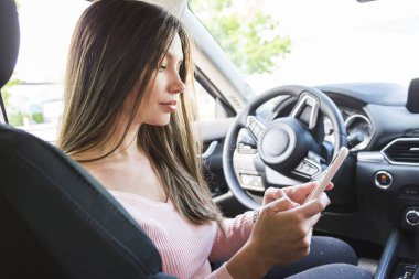 Şoför kız direksiyonda oturuyor.