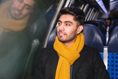 Trendeki yakışıklı genç adam pencereden bakıyor.