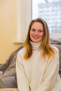 Pencere arkasında süveter giyen genç kız